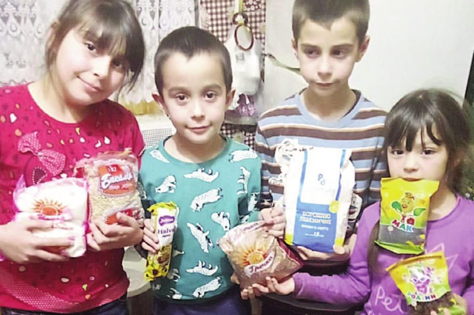 Children in Ukraine holding the food packages they received