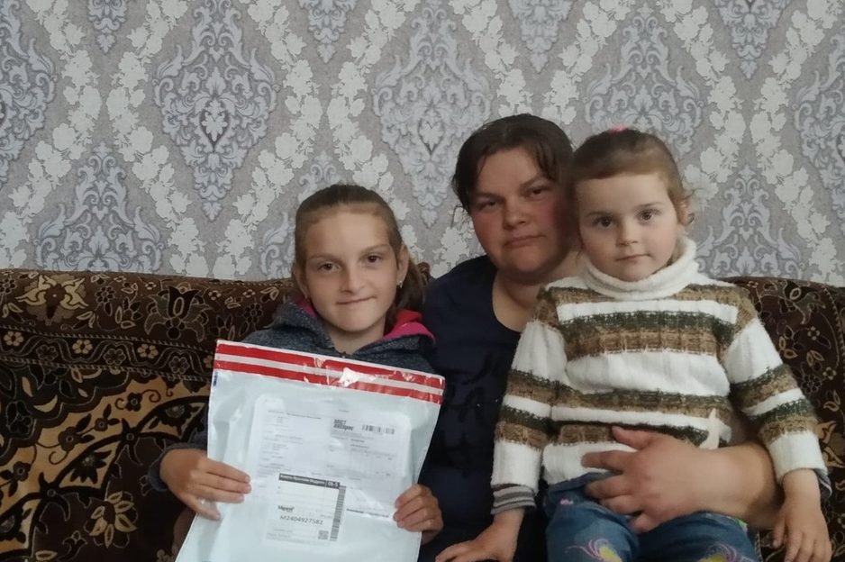 A mother and her children supported by the Open Your Heart project